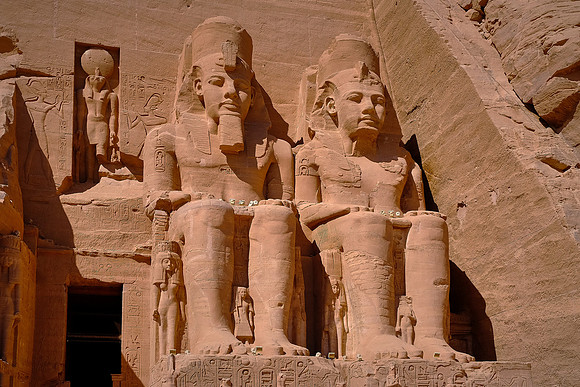 The entrance is flanked by four colossal (66 ft) statues representing Ramses II wearing the double crown of Upper and Lower Egypt.