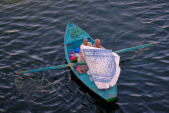 Local entrepreneur ties up to our ship and hopes to exchange fabric for cash.