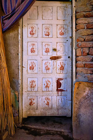 A local door is decorated with handprints of wedding guests dunked in the blood of a slaughtered beef for the occasion.