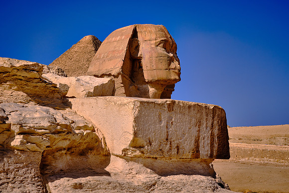 The Great Sphinx reclining with the head of a human, and the body of a lion.  The face of the Sphinx represents the pharaoh Khafre.