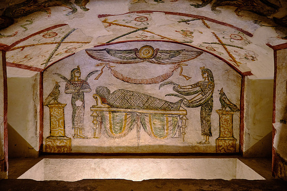 At the front is a façade of two columns topped by Horus falcons and a central winged sun-disk above overseeing the burial process.