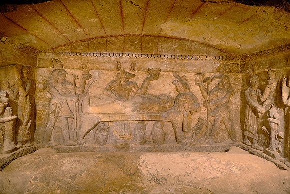 This sarcophagus shows the wolf-headed Anubis wearing Roman soldier garb and who mummifies a body lying on a lion bed.