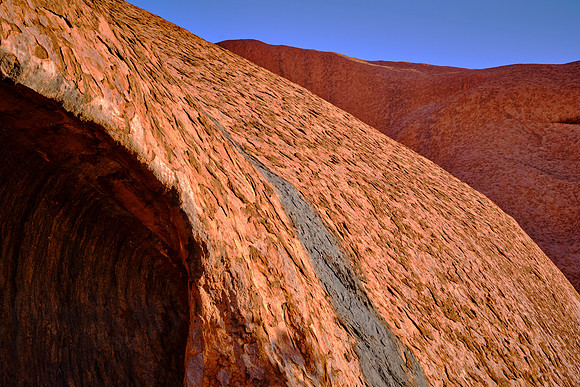 This large sandstone monolith contains feldspar. The iron oxidation gives the rock its red color.