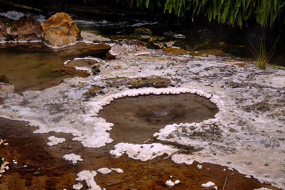 Silica outwash in the hot springs primarily consists of amorphous silica, deposited as waters cool and silica precipitates.