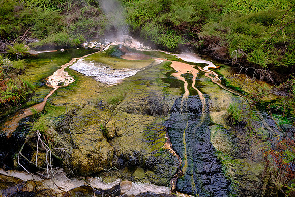 Hot, silica-rich waters deposit opaline silica upon cooling below ~90°C, often with minor sulfur and pyrite framboids.