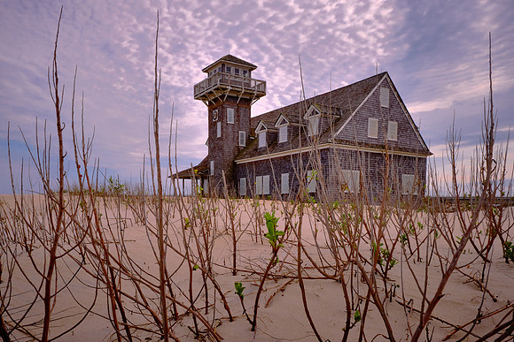 The station is a 1 1/2-story, shingle style rectangular frame building with a lookout tower.  It has a porch that surrounds the building.