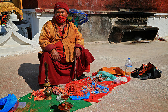 Buddhist monk sells salvation, Boudhanath Stupa, Kathmandu, Nepal