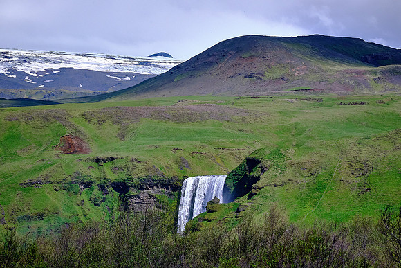 Skógafoss is a waterfall on the Skógá River.  The cliff marks the former coastline.