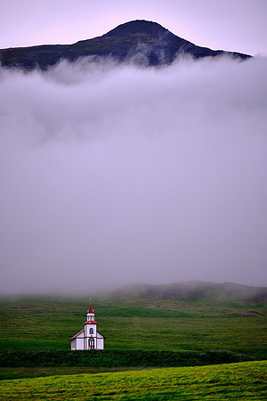 Small red and white church under cloud.