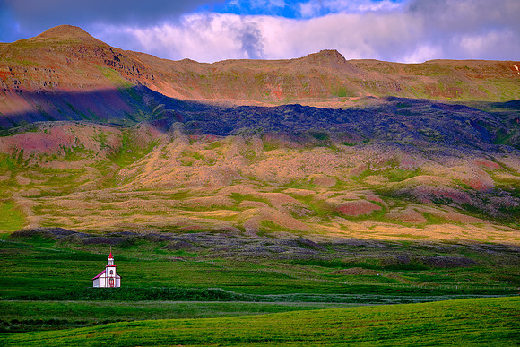 Small red and white church under partial sun.
