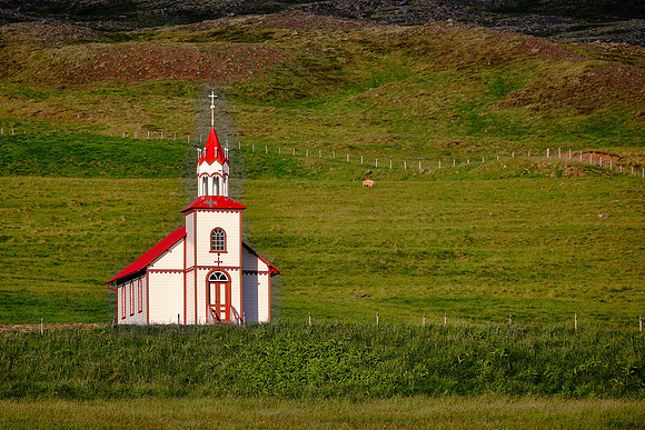 Small red and white church under full sun.