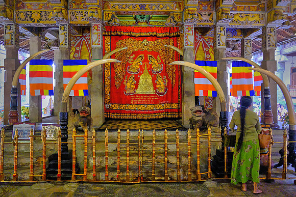Buddhist shrine and pilgrim at The Temple of the Sacred Tooth Relic, Kandy, Sri Lanka