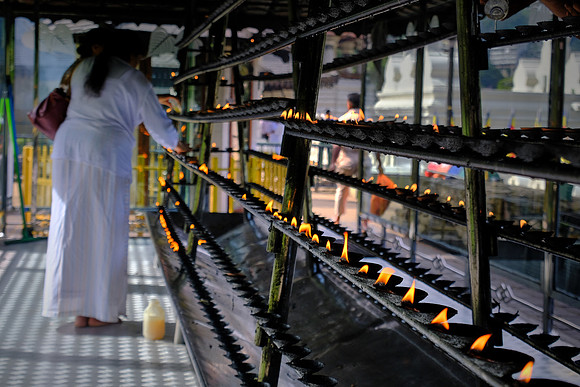 Pilgrims offer incense at The Temple of the Sacred Tooth Relic, Kandy, Sri Lanka