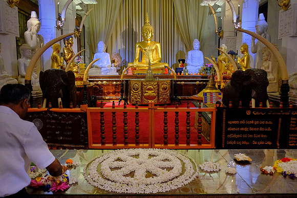 Buddhist shrine and pilgrim at The Temple of the Sacred Tooth Relic, Kandy, Sri Lanka