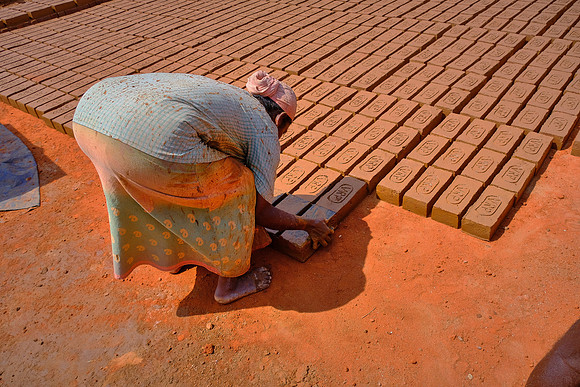 Bricks are placed in the sun to dry before being further baked in an oven.