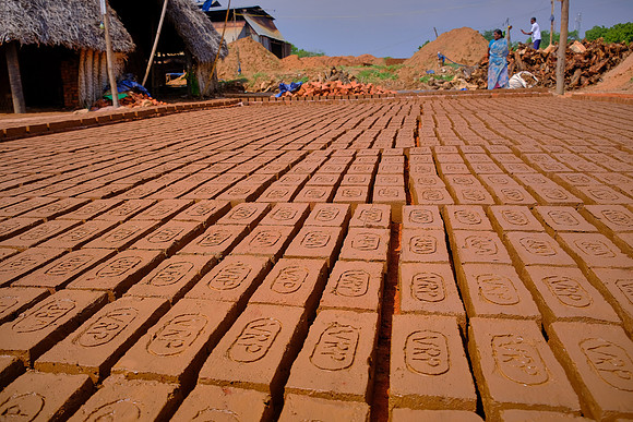 Bricks are placed in the sun to dry before being further baked in an oven.