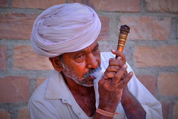 Farmer smokes a mixture of tobacco and molasses in rural Rajasthan, India.