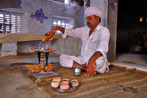 Farmer brews a drink of opium infused water  in rural Rajasthan, India.