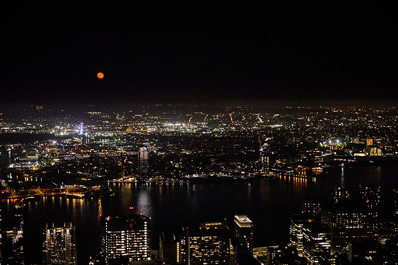Moon rise over New York City at night from the Empire State Building, Midtown Manhattan