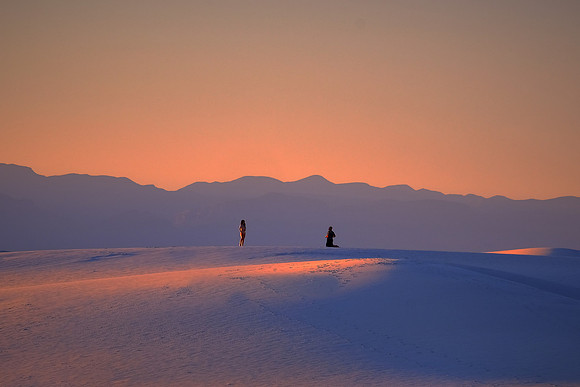 Photographer and model at sunset over White Sands National Monument, New Mexico