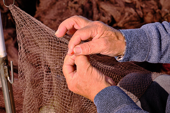 And this fisherman repairs his nets.