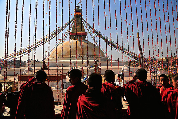 Buddhist monks overlook the Boudhanath Stupa, Kathmandu, Nepal