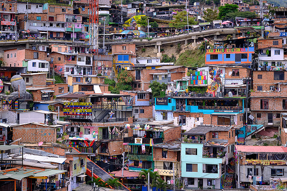 Comuna 13 has street art, performances, graffiti, bright colors, and an energetic environment.
