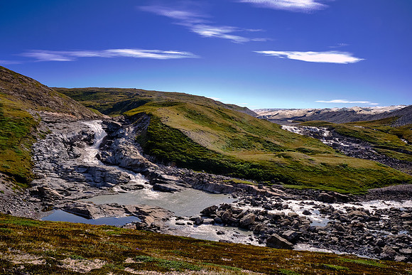 The weight of the ice causes it to slowly "flow", unless stopped by a large obstacle, such as a mountain.