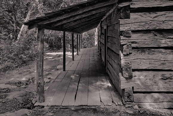 The cabin has a covered porch that spans both sides of the house.